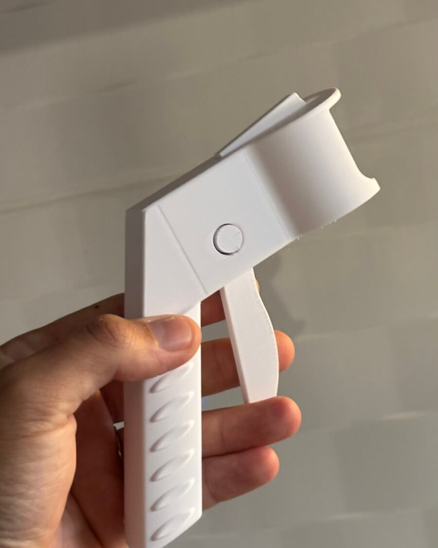 Gatilho pistola branco acoplado a uma lata de spray durante aplicação de tinta sobre uma superfície metálica